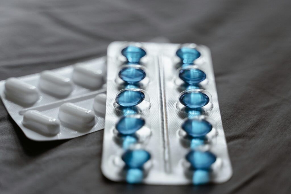 Detailed view of medication in blister packs showcasing blue softgel capsules and white pills.