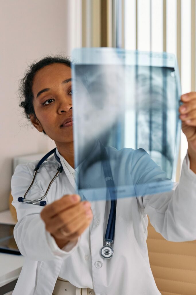 Doctor reviewing x-ray film for diagnosis in a clinical setting.